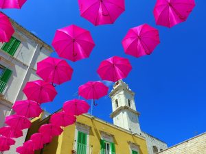 Der erste wärmere Tag und alles wird heiterer. Schirme über der Piazza Giovene in Molfetta